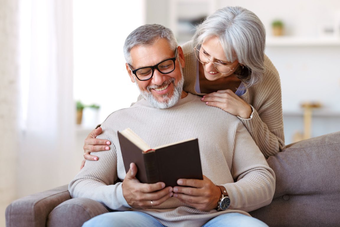 Husband reading book with wife